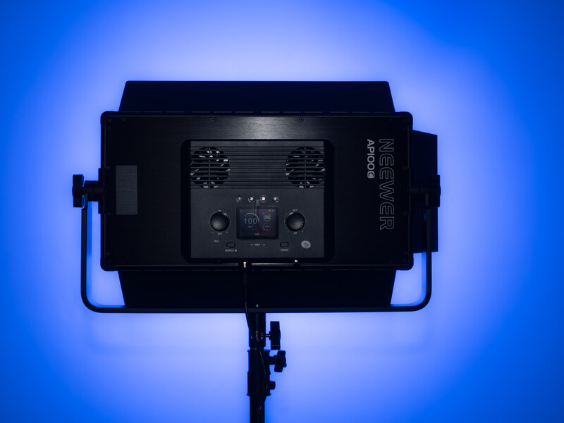Professional LED panel light mounted on stand against blue gradient backdrop.