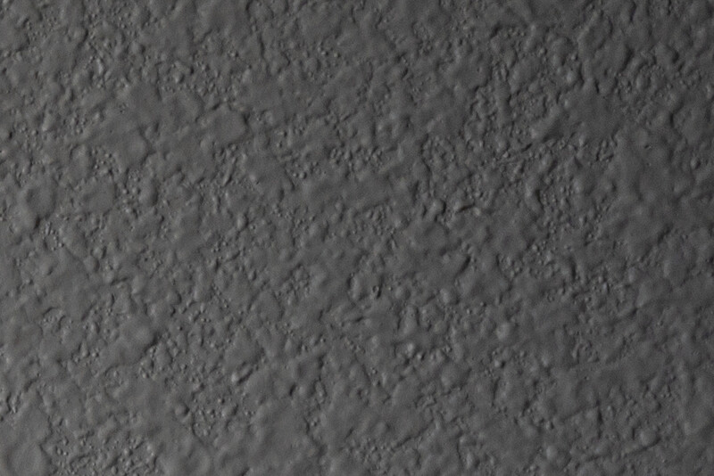 Close-up texture of rough concrete or cement surface with uneven, grainy finish.