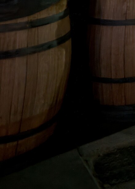Wooden barrels with metal bands positioned in dramatic side lighting against a dark background.