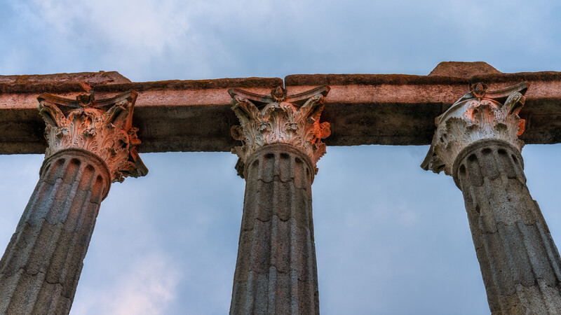 The columns of a roman ruin being lit by the sunset