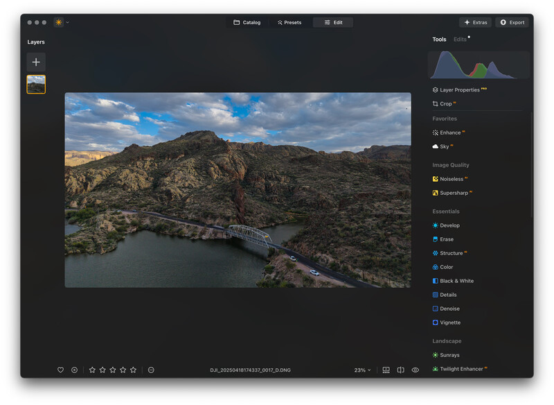 Screenshot of photo editing software displaying an aerial landscape image with mountains, water, and a bridge.
