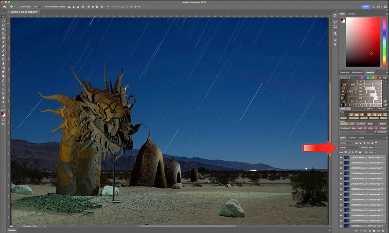 Large golden sculpture of a creature with spiky protrusions in a desert landscape under clear blue sky with star trails.