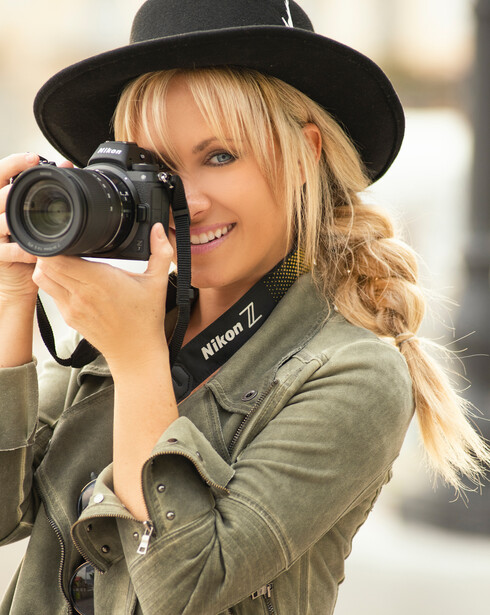 Photographer Dixie Dixon with a Nikon camera and trademark hat