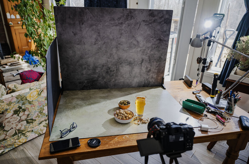Food photography setup with styled props on white surface against dark backdrop, lit by studio lighting.