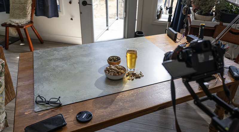 Behind-the-scenes view of a tabletop product photography setup with props and camera equipment.