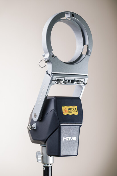 Studio lighting head with reflector ring mounted on stand against white backdrop.