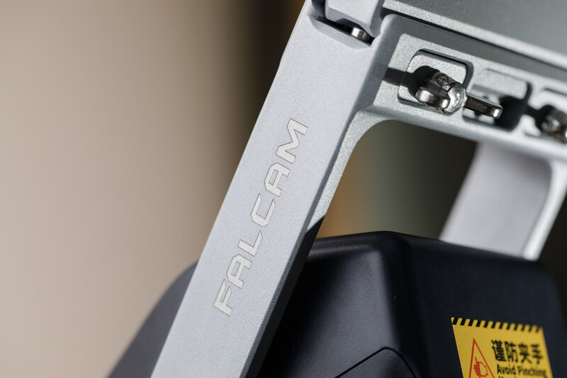 Close-up detail of white camera equipment frame with engraved branding and metal mounting hardware.