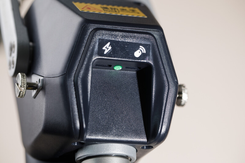 Top view of a camera flash unit showing the control panel with power and mode buttons and a green indicator light.