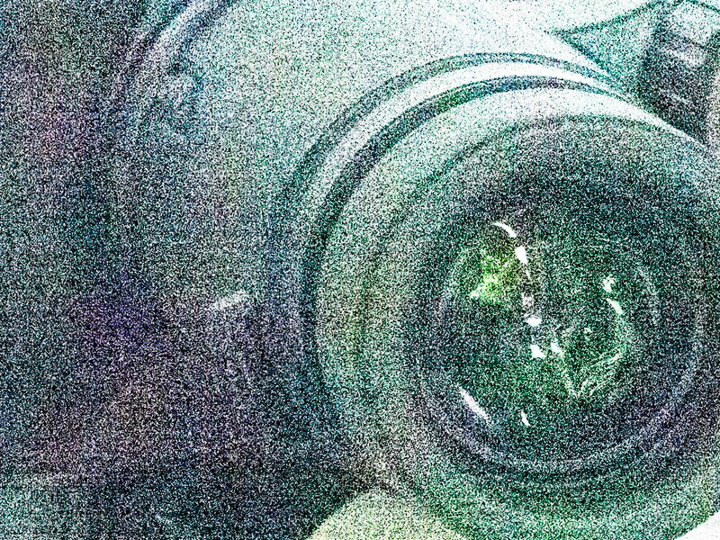 Abstract spiral pattern with concentric circles radiating from a luminous center in green and teal tones.