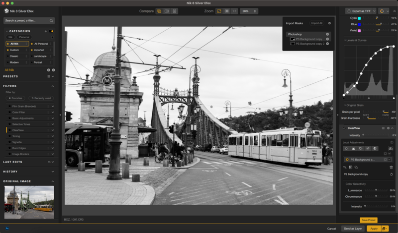 Black and white street scene with vintage tram and historic tower building under power lines.