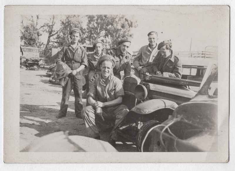 Group of people gathered around a boat or watercraft in what appears to be a dock or waterfront area.