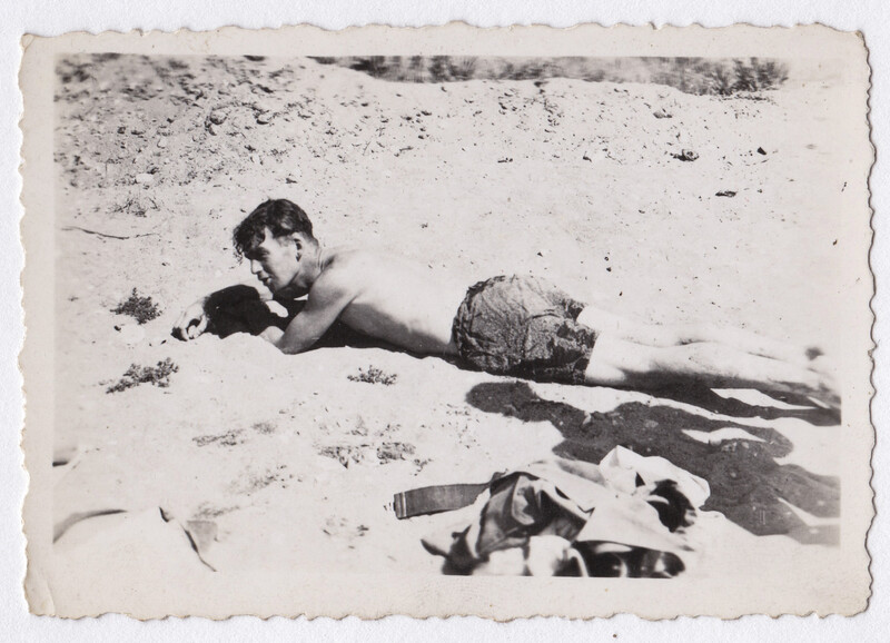 Woman lying on sand beach in vintage black and white photograph.