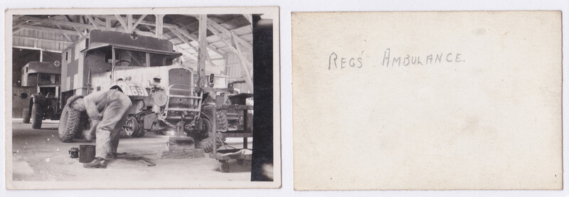 Mechanic working on vintage truck wheel and undercarriage in an industrial garage workshop.
