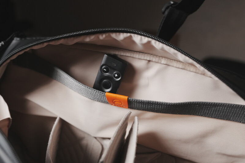 Open camera bag interior showing a wireless microphone system and cable organizer with orange label.