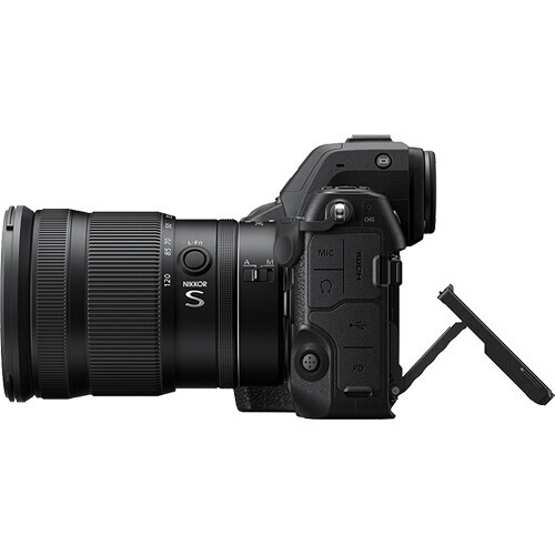 Mirrorless camera with standard zoom lens mounted, shown from side angle with articulating monitor extended.