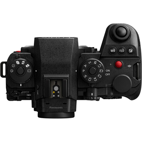 Top-down view of a mirrorless camera with articulating screen and control dials displayed on white background.