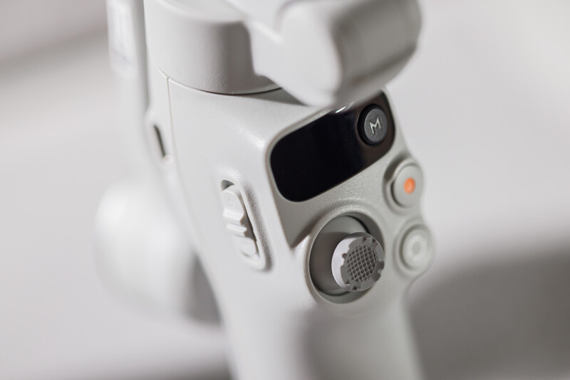 Close-up of a white drone's camera gimbal and control interface with a dark screen and circular dial.