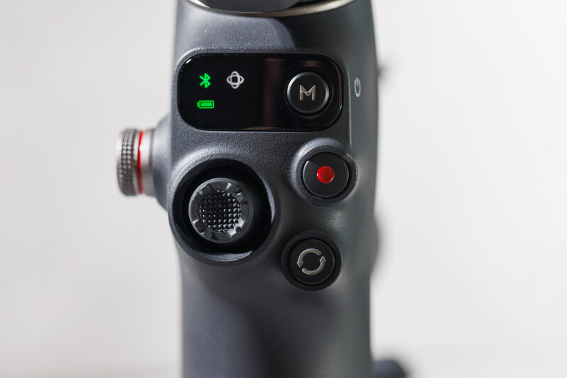 Close-up of a camera gimbal's control panel showing buttons, LED indicators, and a joystick interface.
