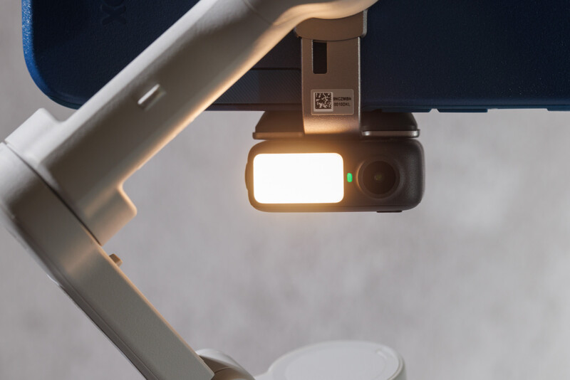 Overhead view of a gimbal-mounted camera with illuminated screen mounted on an articulating arm.