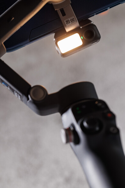 Overhead view of a camera on a white surface with a ring light mounted above it.