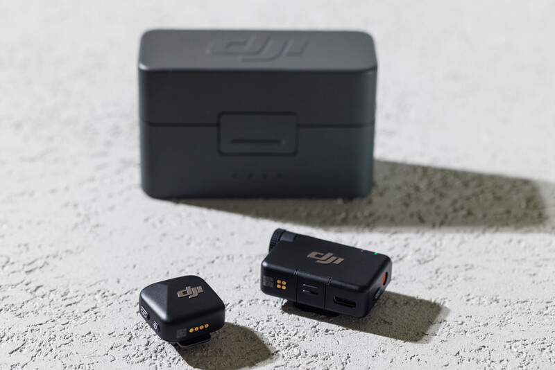 DJI drone batteries and carrying case arranged on concrete surface with shadow.