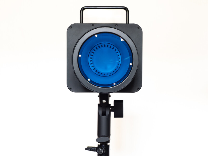 Studio lighting fixture with blue gel filter mounted on adjustable stand.