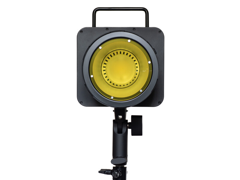 Studio lighting fixture with yellow diffuser dome mounted on adjustable stand with handle.