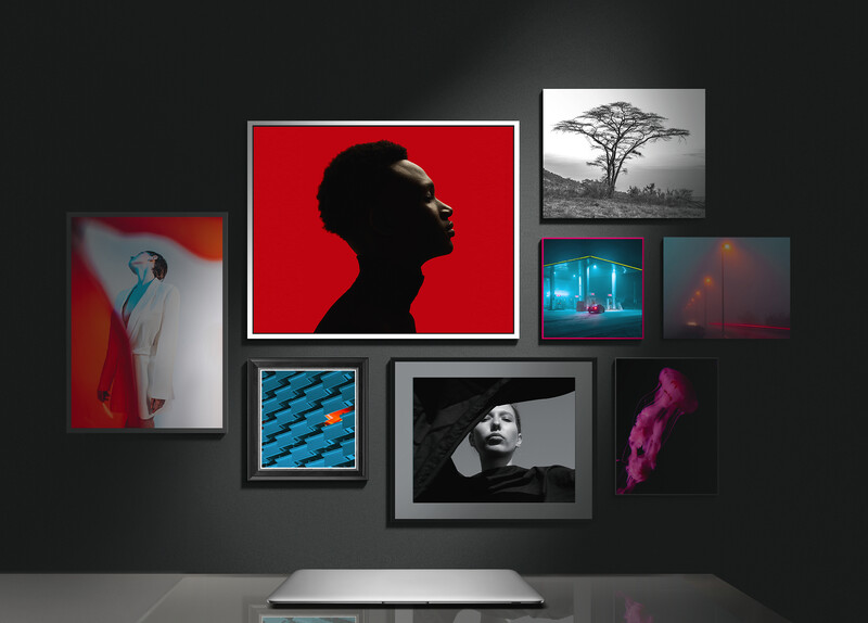 Monitor displaying a gallery wall of eight framed photographs with varied subjects and moods against a dark background.