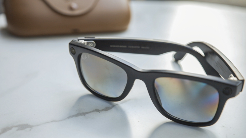 Black-framed sunglasses with reflective lenses on a marble surface.