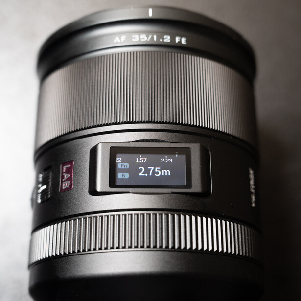Telephoto lens with AF 32/1.2 marking and LCD display showing 2.75m focus distance.