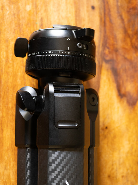 Ball head tripod mount with panoramic rotation dial mounted on carbon fiber tripod leg.