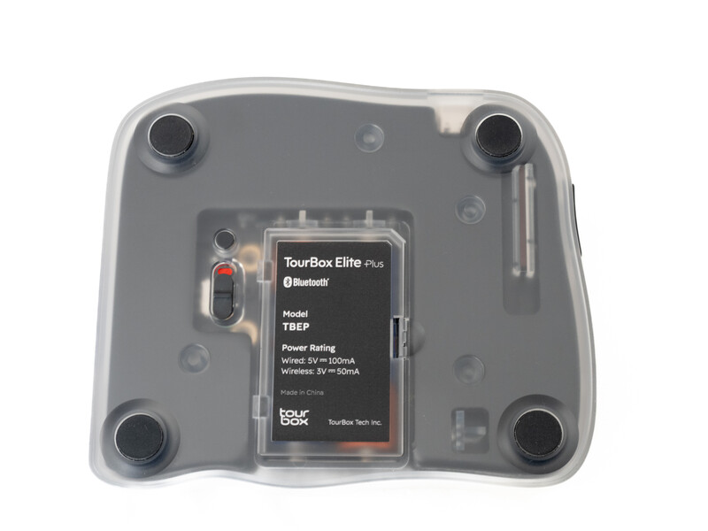 Bottom view of a wireless audio device with transparent casing showing internal battery and circuit components.