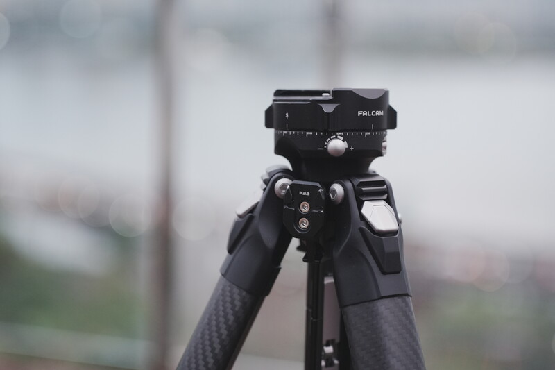 Falcon tripod head mounted on carbon fiber tripod legs with blurred background.