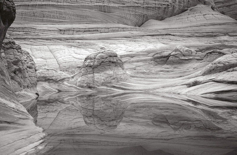 Layered rock formations with flowing striations and curved geological patterns carved by water erosion.