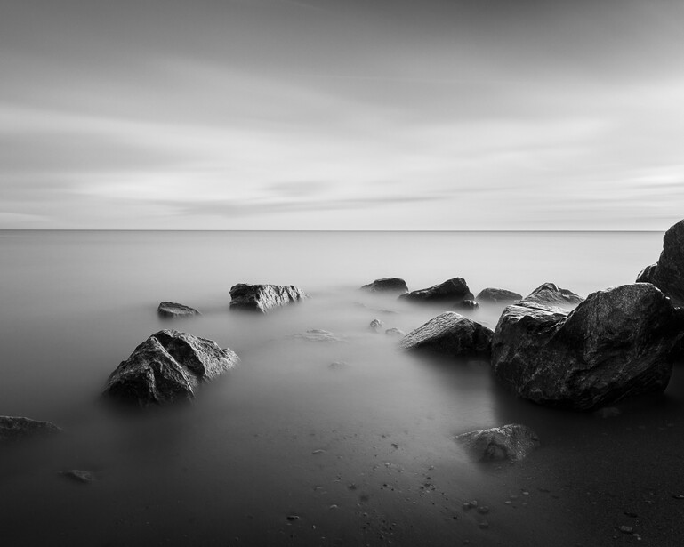 Black and white long exposure photograph of rocks in Lake Michigan