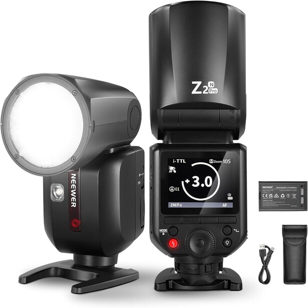 Two black camera flash units displayed with accessories including a wireless trigger and charging cable.