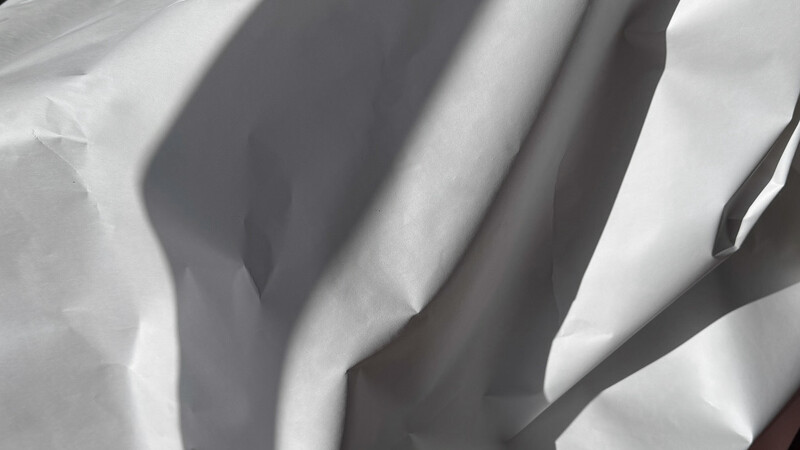 Abstract black and white close-up of draped fabric with dramatic shadows and highlights.