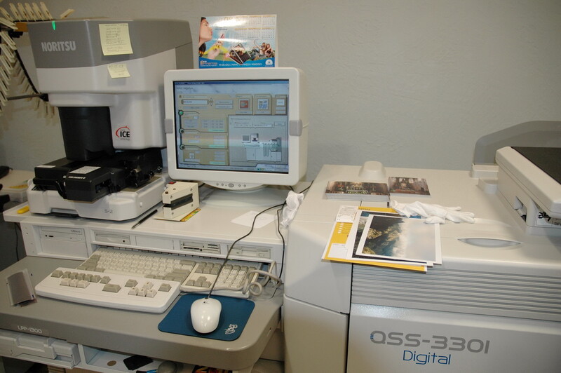 Vintage photography lab workstation with CRT monitor, scanner, and digital printer from early 2000s era.