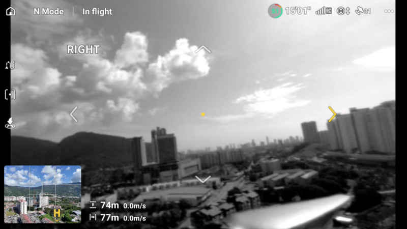 Screenshot of drone flight interface showing aerial view of urban cityscape with mountains and river.