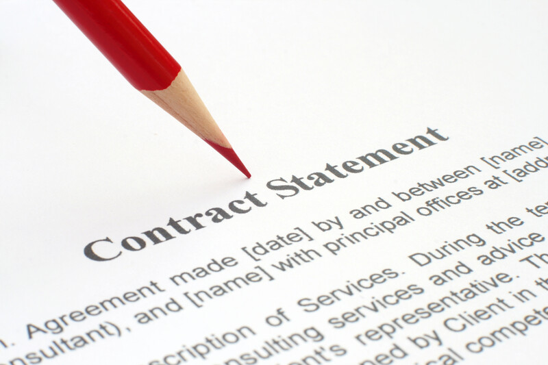 Red pencil pointing at Contract Statement text on printed document.