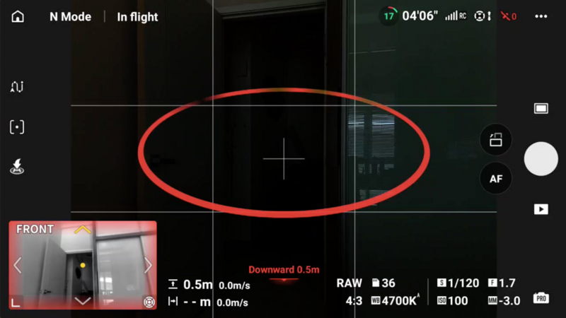 Screenshot of drone camera interface showing autofocus tracking box around building facade during flight.