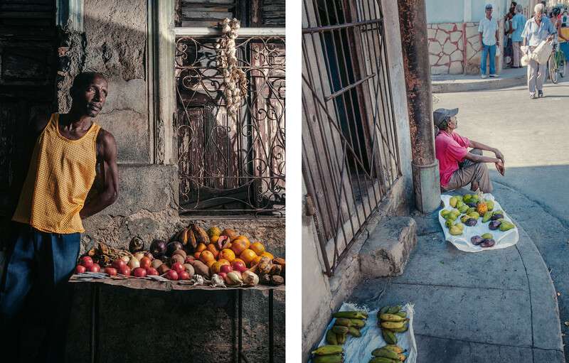 Street vendors displaying fresh produce at their outdoor market stalls in an urban neighborhood.