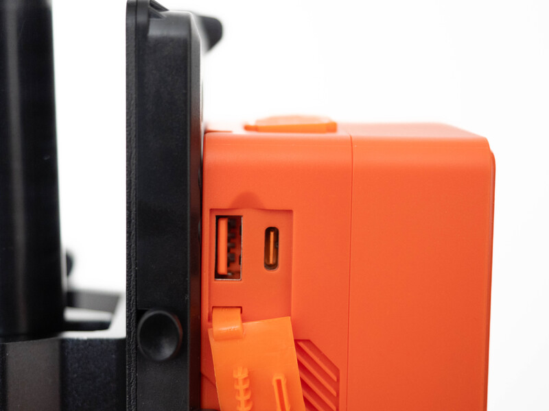 Close-up detail of an orange camera or device body next to black plastic components.