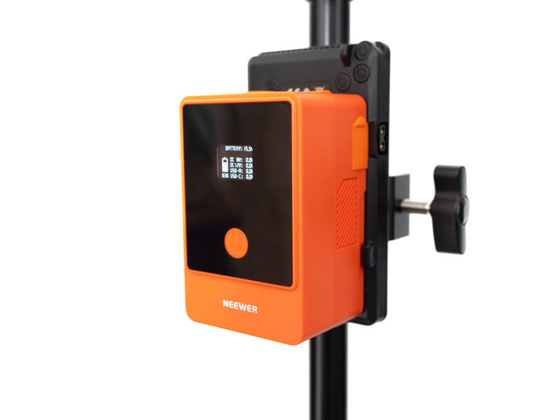 Orange and black lighting control unit mounted on a vertical pole with small display screen and adjustment knob.