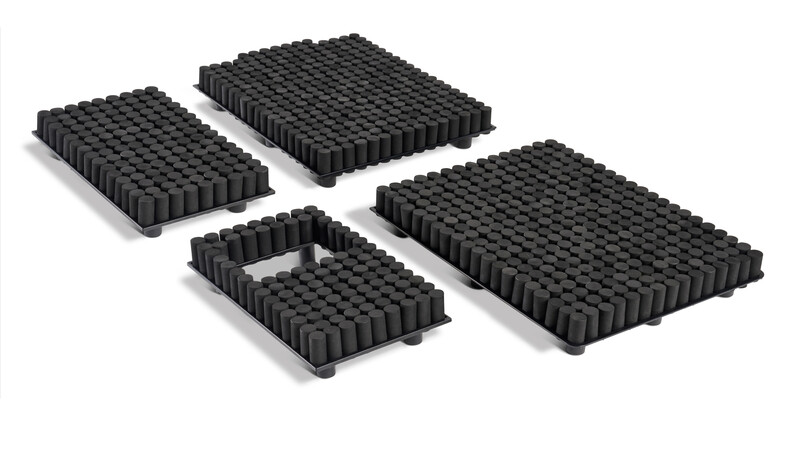 Four black rubber camera lens filter stacks arranged on white surface with shadows.