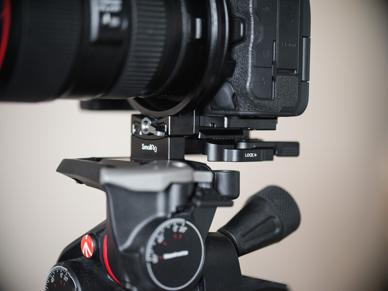 Camera lens mounted on a fluid head tripod with adjustment dials visible from above.