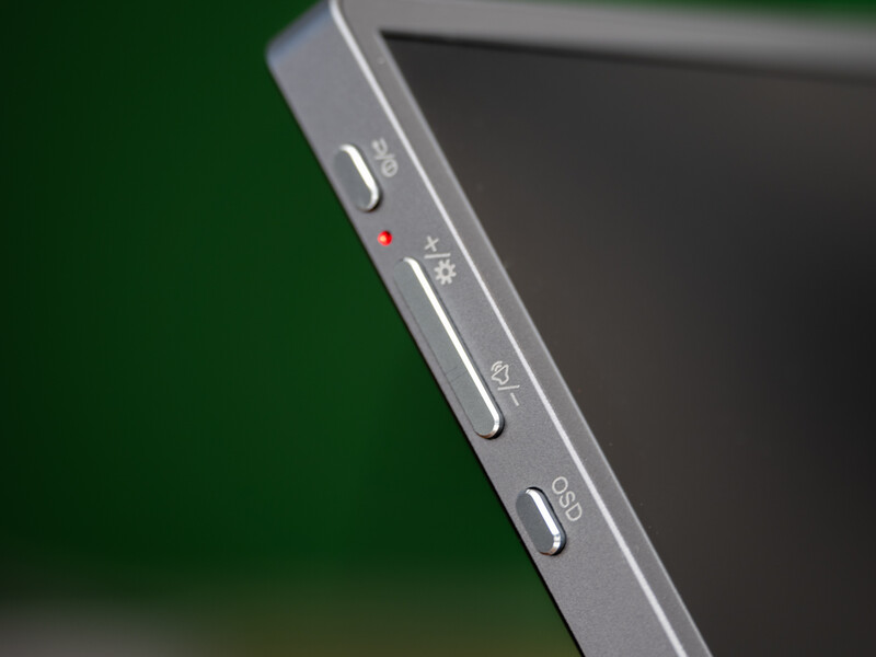 Close-up of camera LCD screen controls showing physical buttons and indicator lights on gray device edge.
