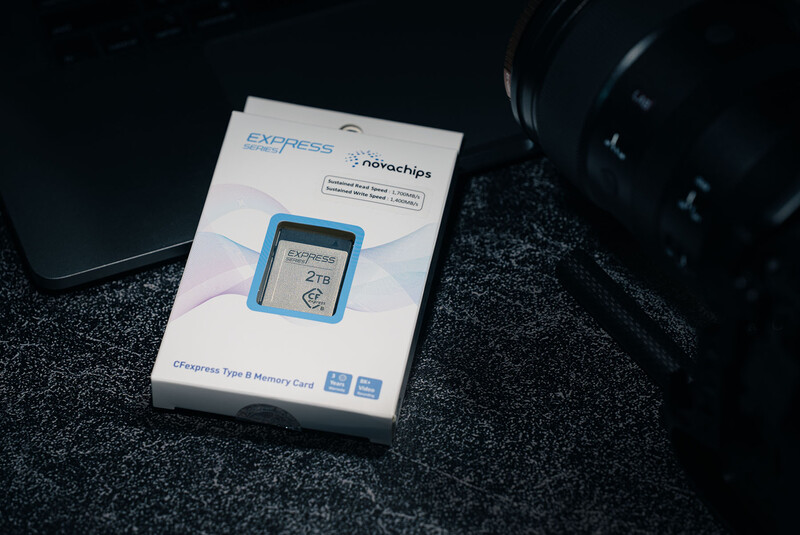 Express One charger packaging with blue device displayed on box, photographed on dark fabric surface.