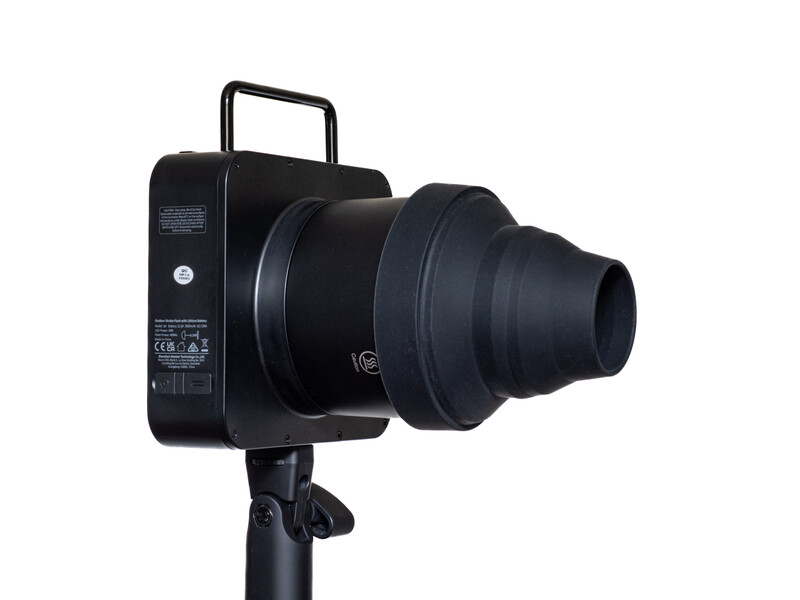 Black compact projector mounted on tripod with telephoto lens attachment and carrying handle.