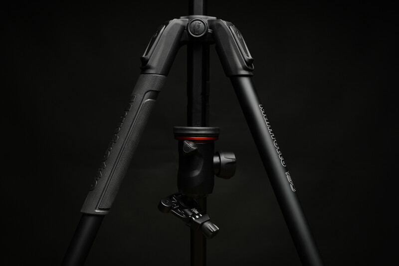 Professional tripod with ball head and center column against black background.